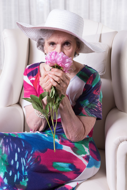 Aktive Seniorin riecht eine Blume - Foto, Bild