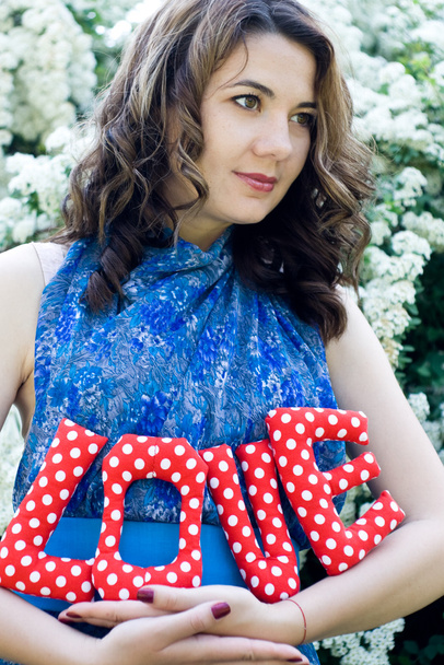 The girl in a blue dress holding a textile fabric letters - Foto, Bild