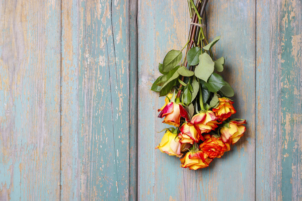Bando de rosas cor de laranja penduradas na porta de madeira
 - Foto, Imagem
