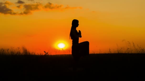 Sziluettje a fiatal lány gyakorló jóga a Sunset - Felvétel, videó