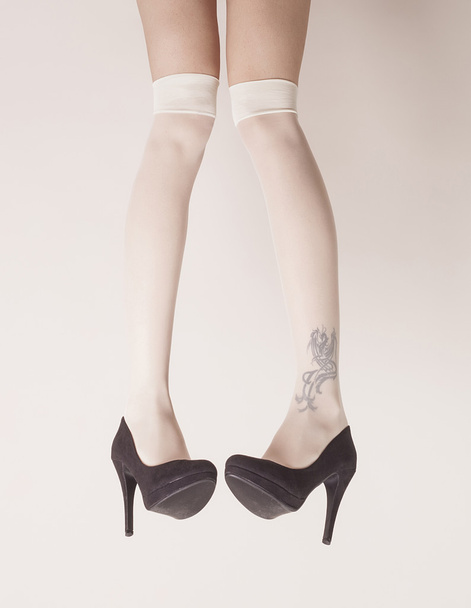 Female legs up in the air wearing heels - Фото, изображение