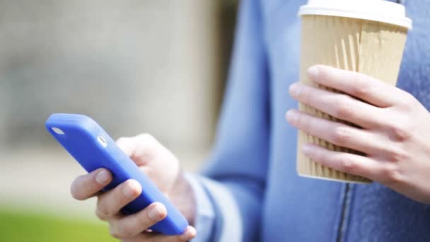 smiling woman with coffee cup and smartphone - Video, Çekim