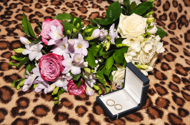 Wedding rings and two bouquets flowers. - 写真・画像