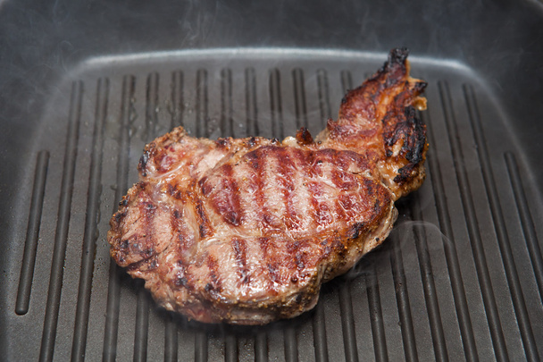 braden biefstuk op een geribbelde grill pan - Foto, afbeelding