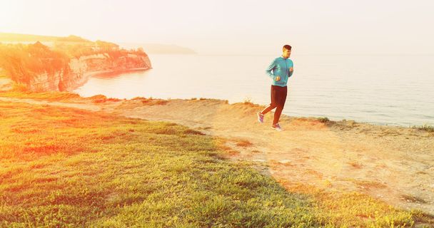 Hombre corriendo en la costa en el día soleado
  - Foto, Imagen