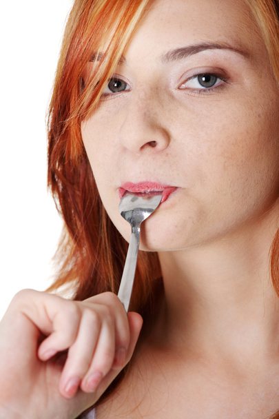 Teen student licking spoon. - Foto, afbeelding