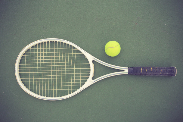 теннисная ракетка и мячи на теннисном корте винтажного цвета
 - Фото, изображение