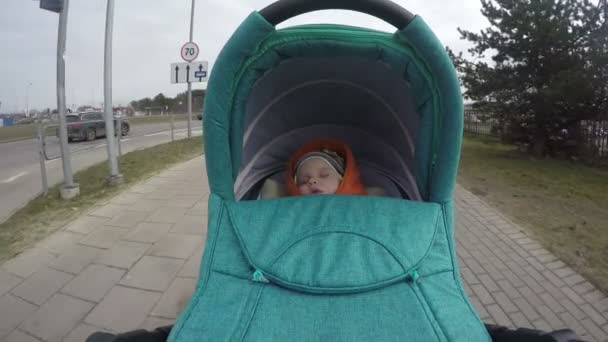 little kid with romper sleep buggy ride across city street. 4K - Footage, Video