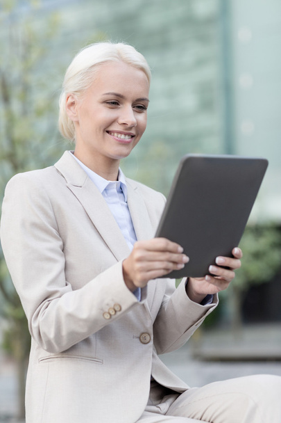 smiling businesswoman with tablet pc outdoors - Fotó, kép