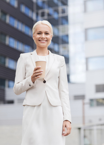 smiling businesswoman with paper cup outdoors - Zdjęcie, obraz