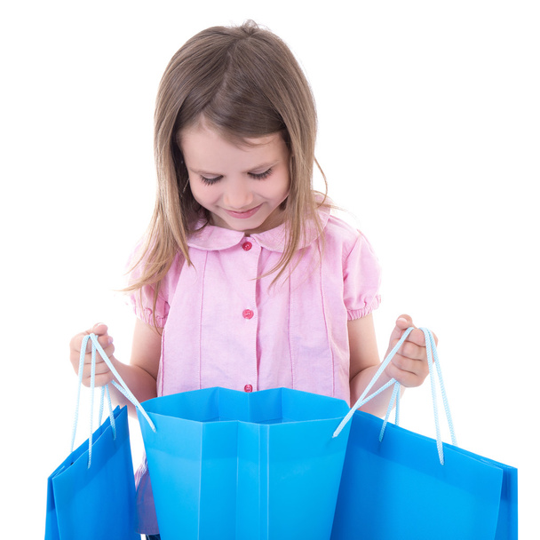 shopping concept - cute little girl with bags isolated on white - Foto, imagen