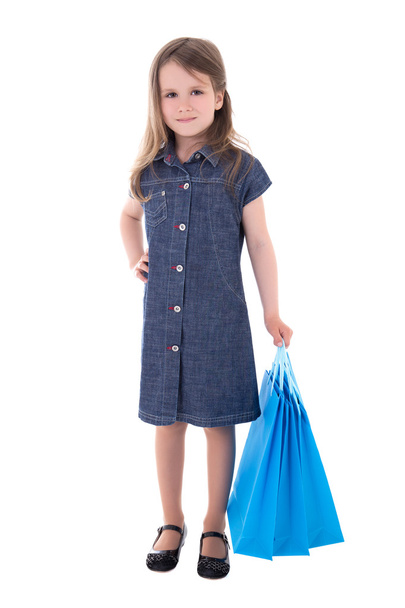 cute little girl in denim dress with shopping bags isolated on w - Φωτογραφία, εικόνα