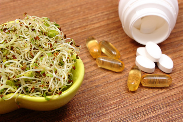 Brotes de alfalfa y rábano con suplementos de tabletas, nutrición saludable
 - Foto, Imagen