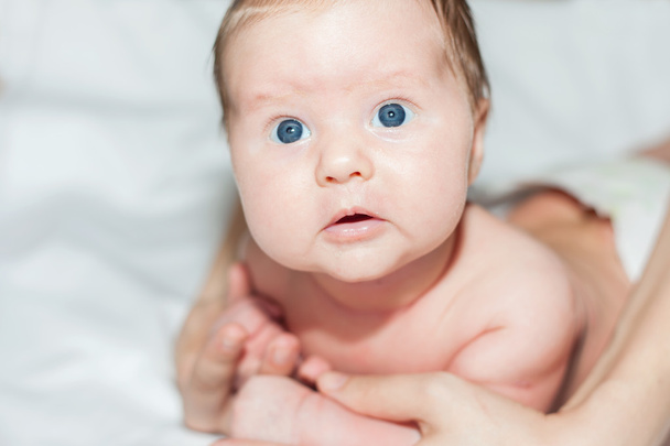 neonata sdraiata sul suo stomaco su un letto bianco
 - Foto, immagini