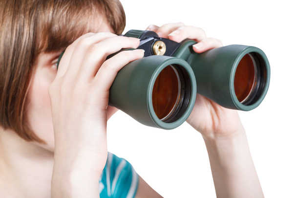 girl looks through field glasses isolated on white - Foto, afbeelding
