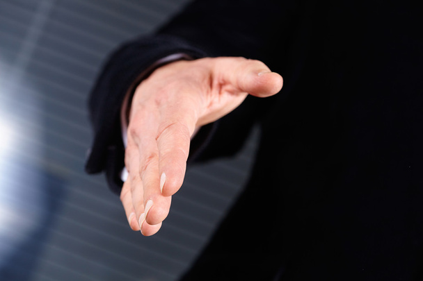 Бизнесмен протягивает руку, чтобы пожать руку - Фото, изображение