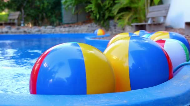 Bolas de praia coloridas flutuando na piscina
 - Filmagem, Vídeo
