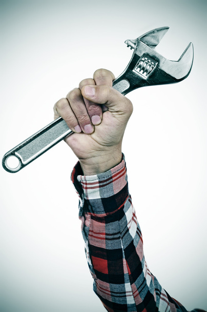 Hombre con llave ajustable en la mano
 - Foto, imagen