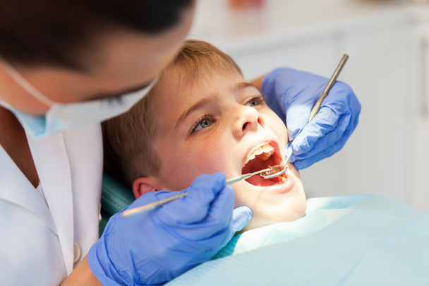 dentist examining boys teeth - Foto, imagen