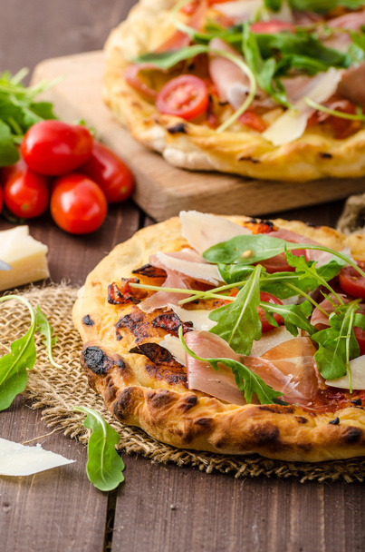 olasz pizza parmezán sajtot, sonkát és rukkolával - Fotó, kép