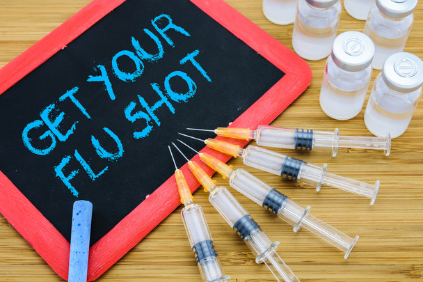 Get Your Flu shot written on chalkboard with vaccine in syringes - Фото, зображення
