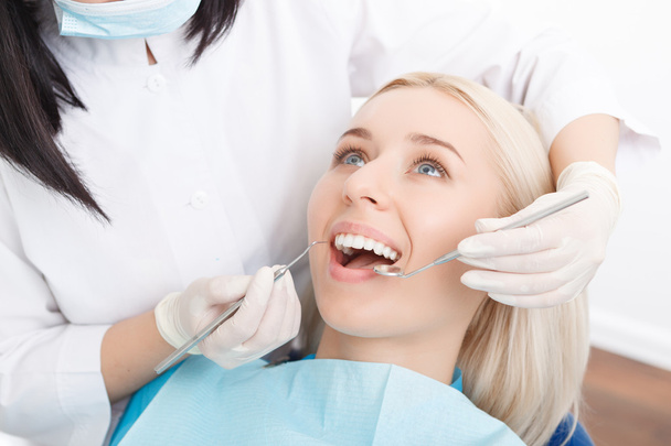 Woman having her teeth examined by dentist  - Foto, Bild
