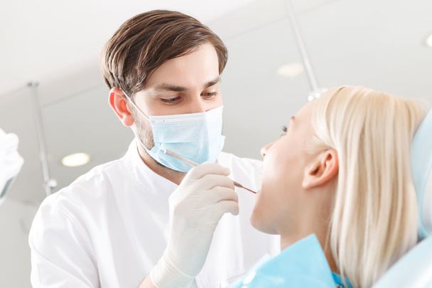 Dentist examining teeth of his client - Zdjęcie, obraz