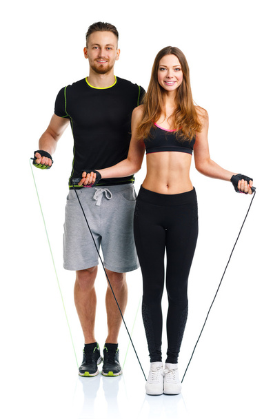 Coppia atletica felice - uomo e donna con corde sul bianco
 - Foto, immagini