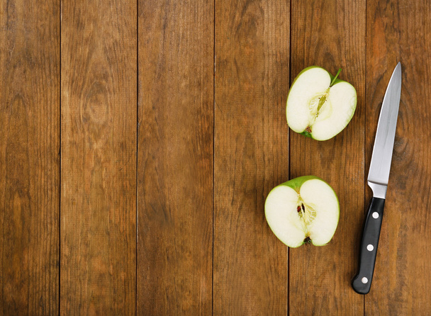 Halves of apple with knife on wooden background - Foto, immagini