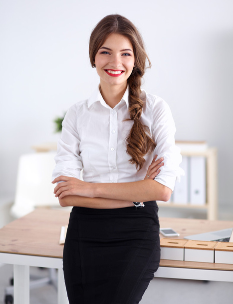 Attractive businesswoman with her arms crossed  standing in office - Fotó, kép
