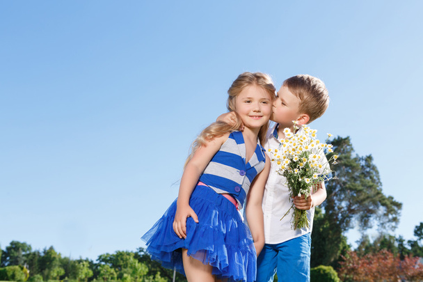 Pleasant little boy and girl kissing.  - Foto, afbeelding