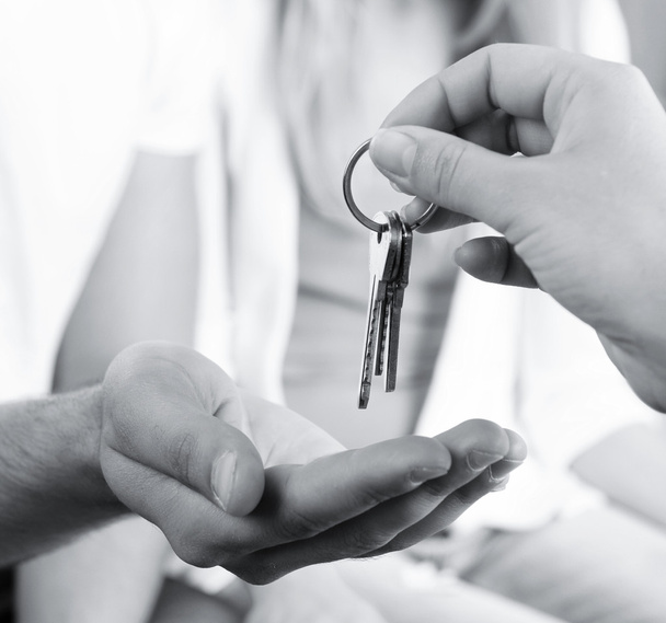 Immobilienmakler übergibt Schlüssel an junges Paar, Nahaufnahme - Foto, Bild