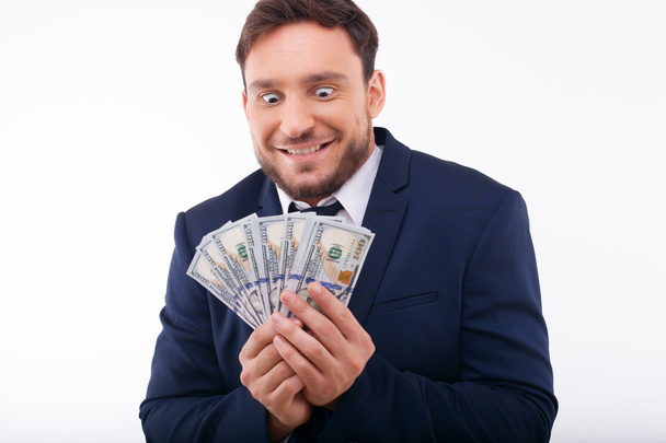 Cheerful young guy is crazy about dollars - Foto, Imagen