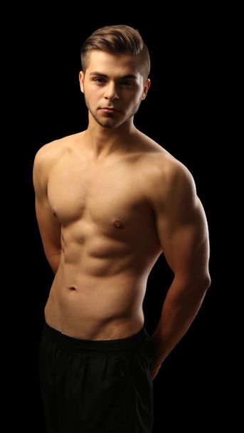 Muscle young man on dark background - 写真・画像