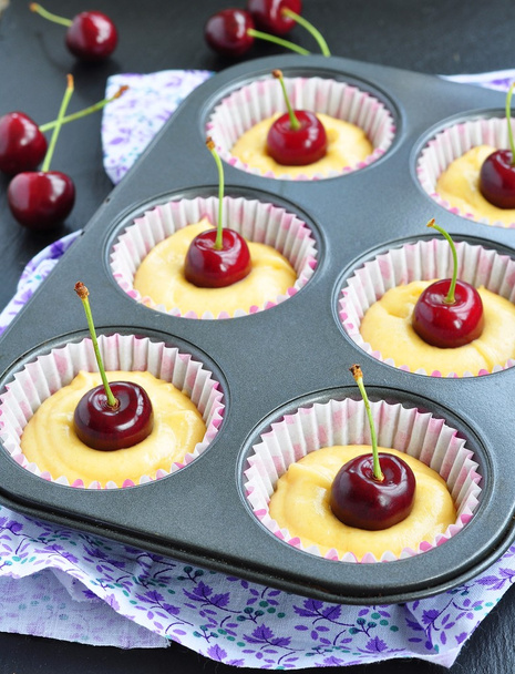 A tray of raw muffins with cherry. Ready for insertion into the oven. - Fotografie, Obrázek