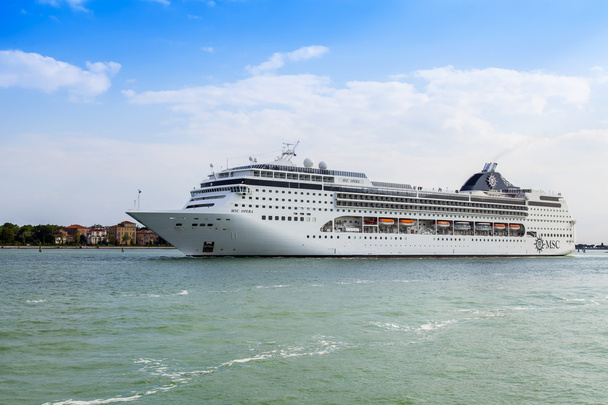 VENICE, ITALY - on MAY 1, 2015. The cruise ship Opera leaves seaport of Venice and passes by Lido's island - 写真・画像