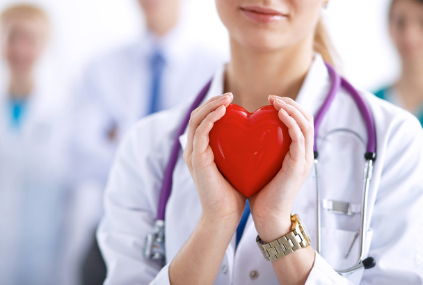 Female doctor with stethoscope holding heart - Foto, Bild
