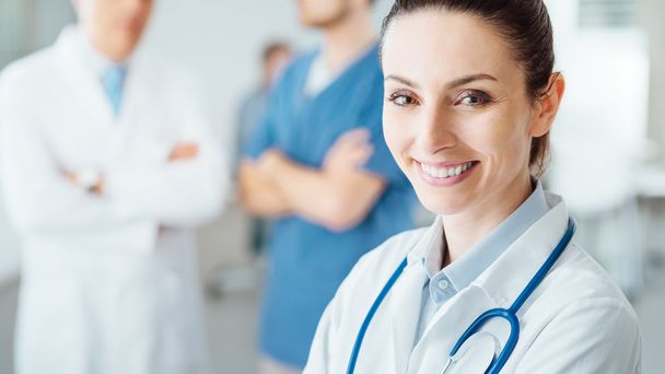 Professional female doctor posing and smiling - Photo, Image
