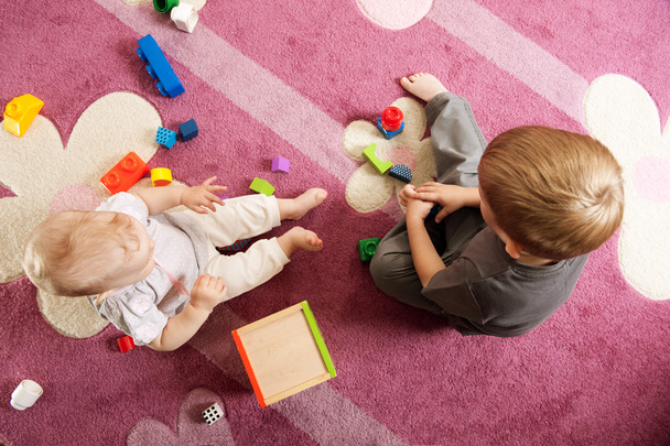 Брат і сестра грають з іграшковими блоками
 - Фото, зображення