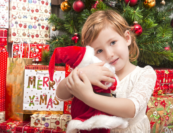 Enfant avec poupée de Père Noël devant l'arbre de Noël
 - Photo, image