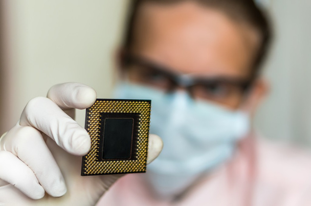 Ученый показывает компьютерный микрочип перед ремонтом электрона
 - Фото, изображение