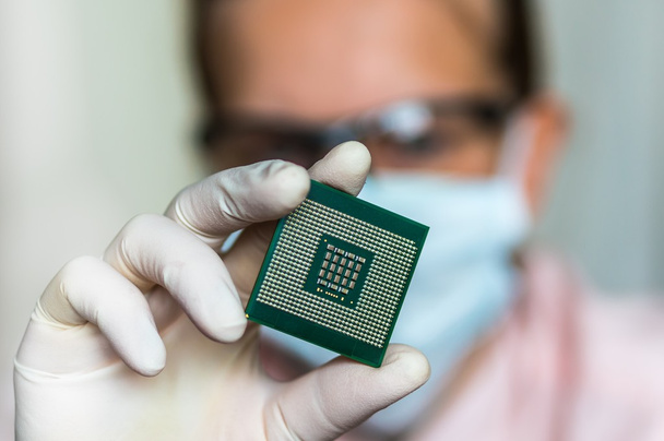Ученый показывает компьютерный микрочип перед ремонтом электрона
 - Фото, изображение