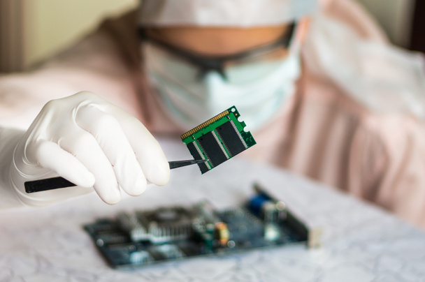 Ученый ремонтирует электронную цепь и держит поврежденный электро
 - Фото, изображение