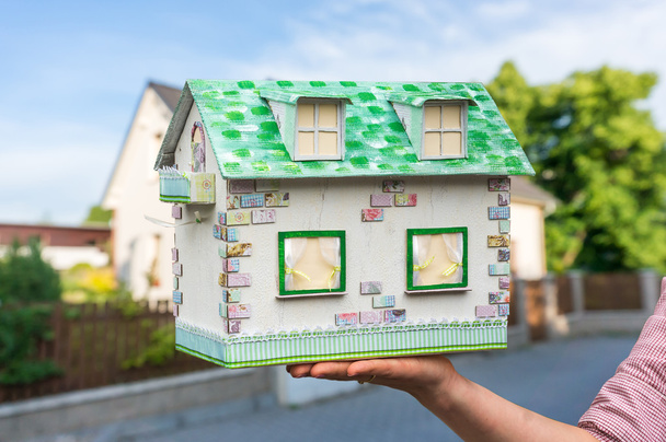 Агент по недвижимости держит образцовый дом из бумаги
 - Фото, изображение