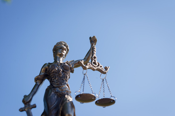 скульптура их, фемиды или богини справедливости на ярко-голубом фоне неба
 - Фото, изображение