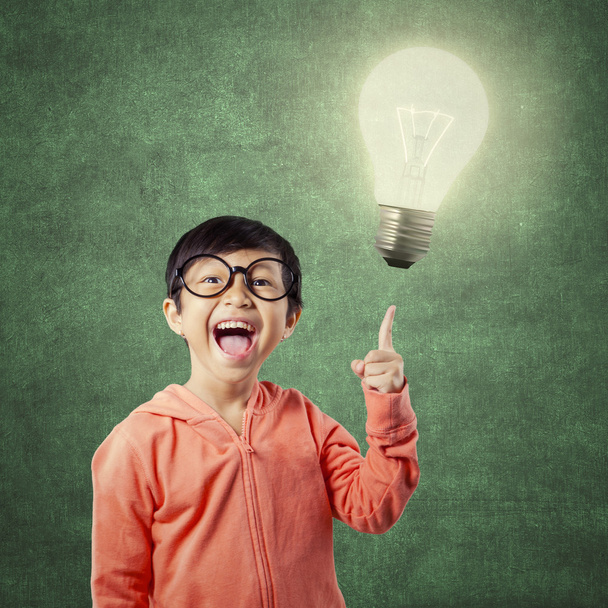 Brilliant student pointing at bright light bulb - Photo, Image