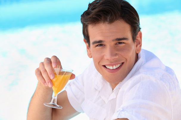 Young man enjoying an orange juice - Foto, imagen