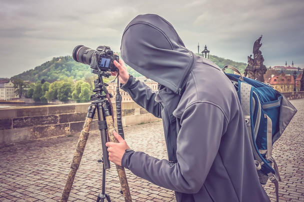 Photographer in hooded sweatshirt photographs of Charles Bridge  - Fotoğraf, Görsel