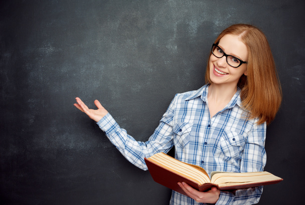 happy girl student with glasses and book from blank blackboard - Φωτογραφία, εικόνα