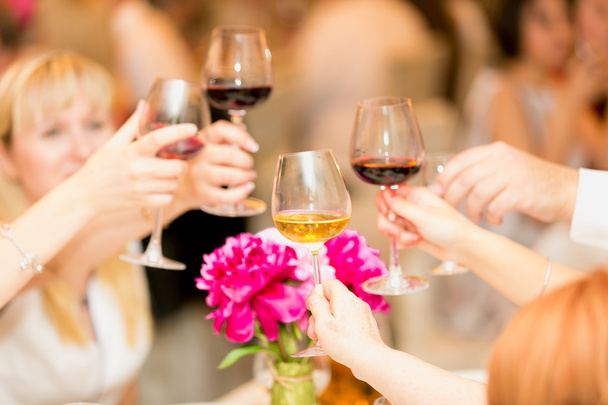 Closeup of hands clinking glasses with red and white wine - Photo, Image